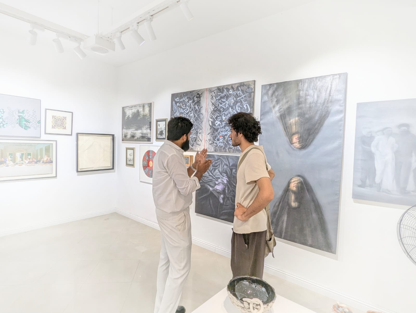 Khuzaima Ayaz discussing his work with a visitor at The Summer Show 2026